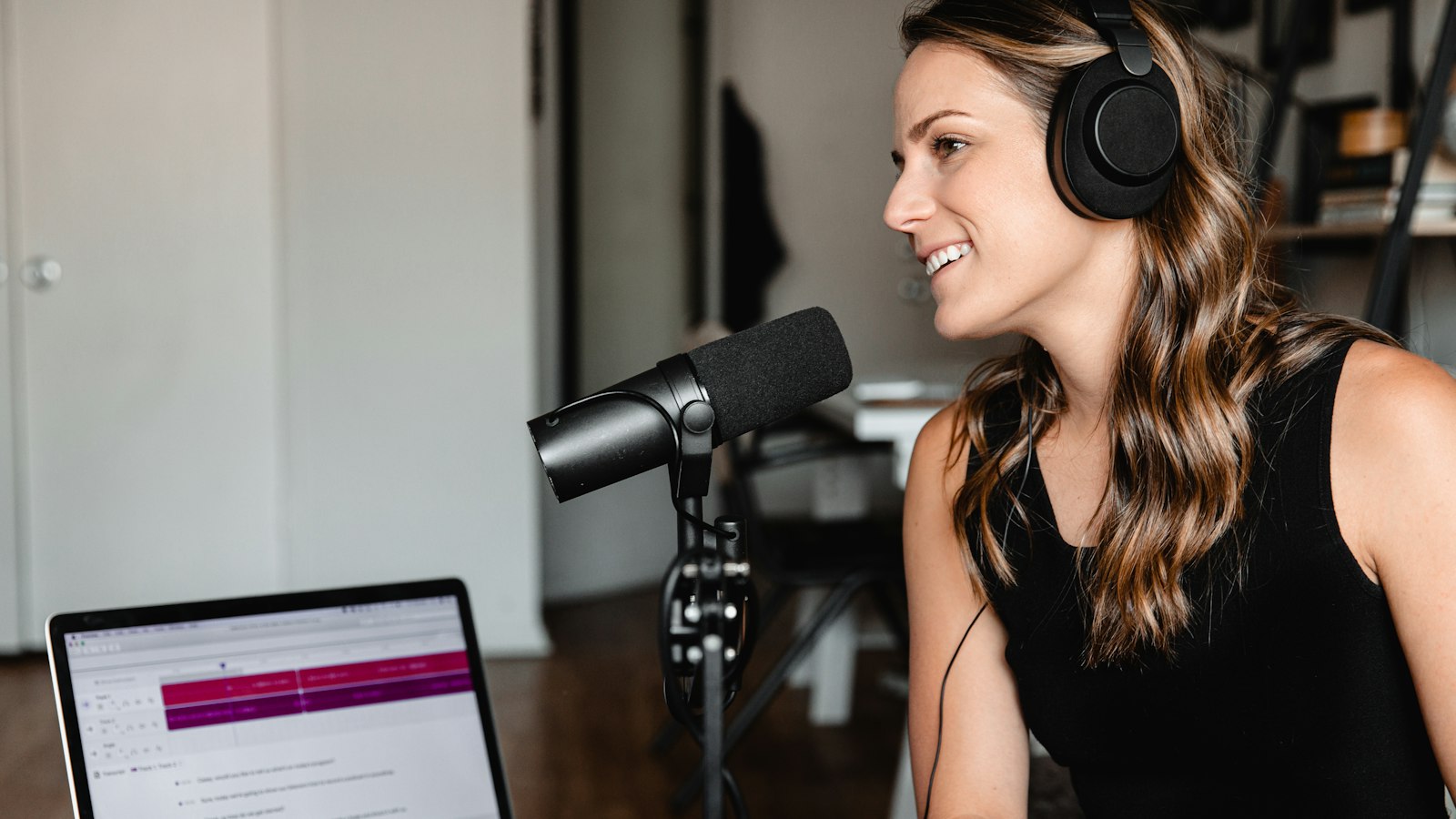Podcast host wearing headphones speaking into a microphone