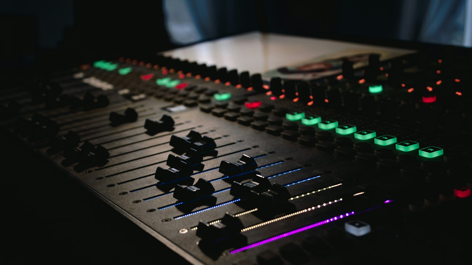 Mixing console with illuminated level meters in a dark studio